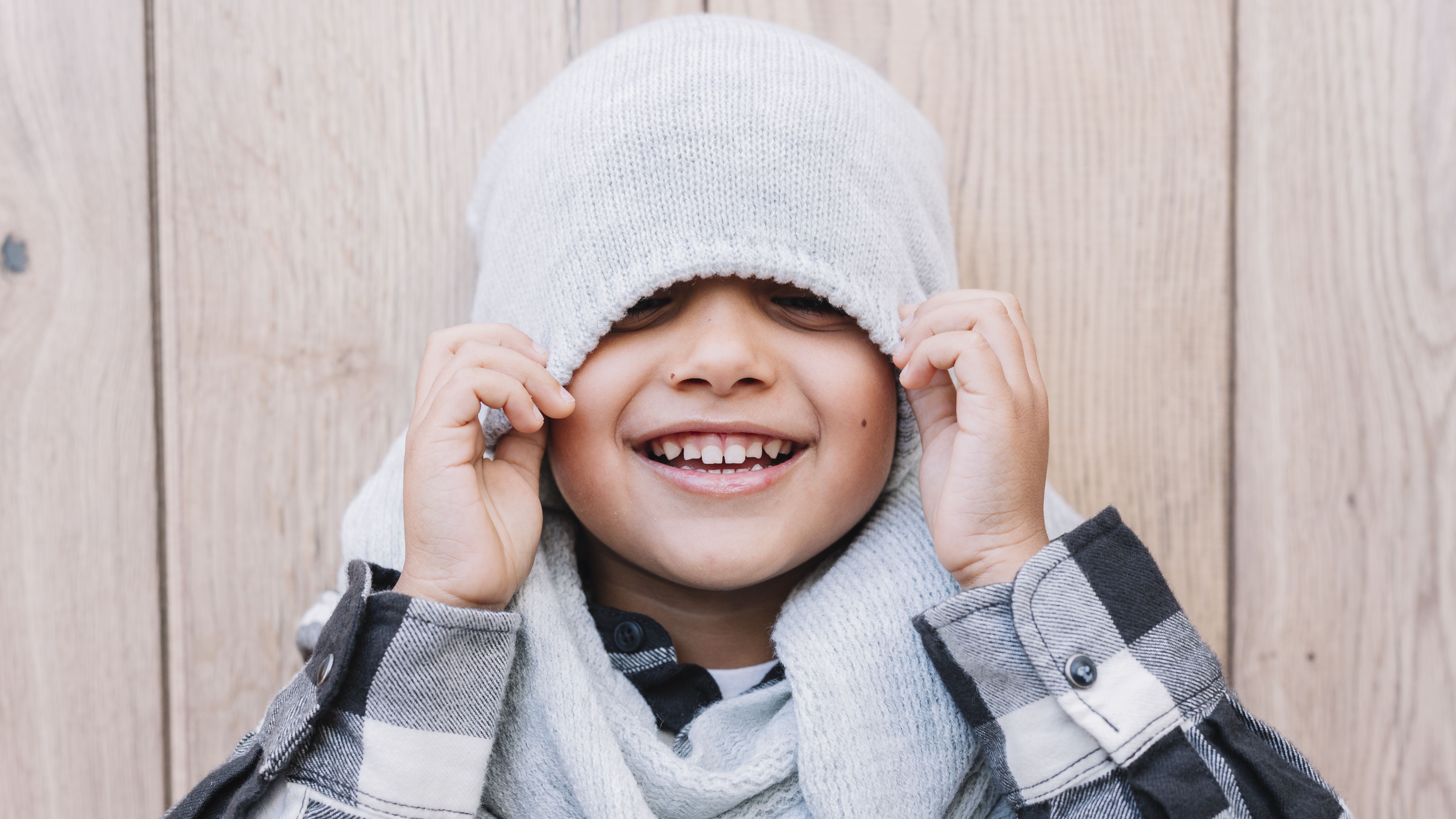 Little Boy Covering Eyes With Winter Cap